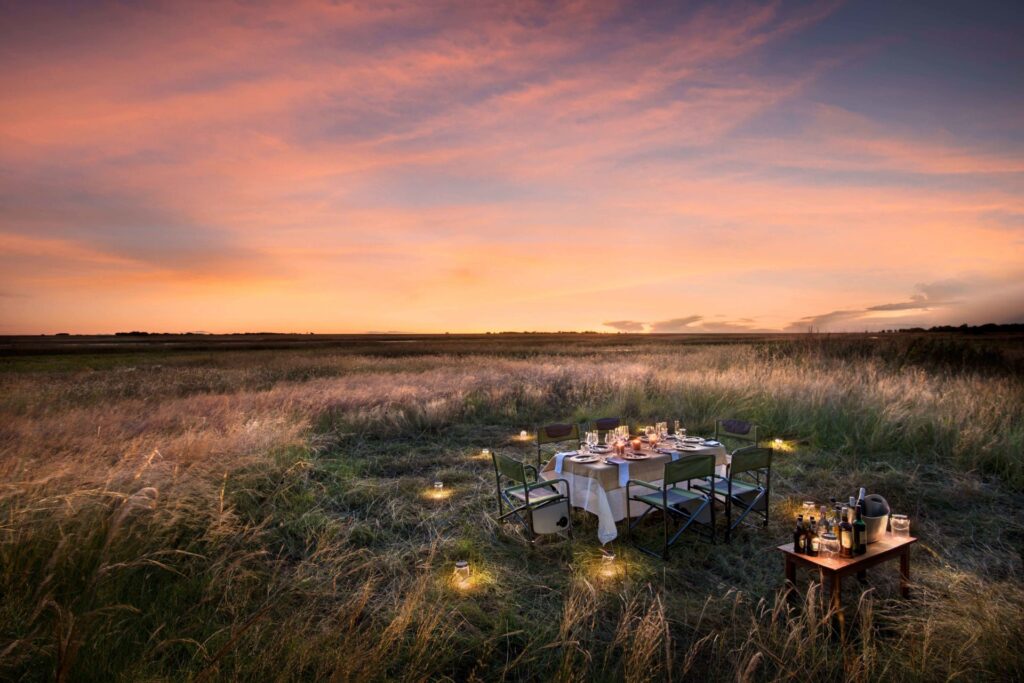 Image of a table decked for dinner under the stars at King Lewanika Camp in Zambia | Planet Africa Safaris | Blog | Which Destination To Visit in Africa Each Month