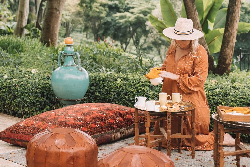 Image of a guest pouring tea at a garden table at Gibb's Farm in Tanzania | Planet Africa Safaris | Blog | Gibb's Farm
