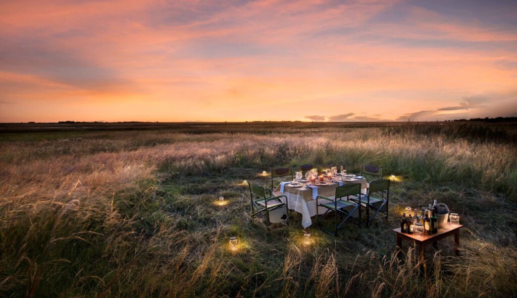 Image of a table decked for dinner under the stars at King Lewanika Camp in Zambia | Planet Africa Safaris | Blog | Which Destination To Visit in Africa Each Month